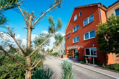 a street in front of a red building at Hotel Residenz in Schnelldorf
