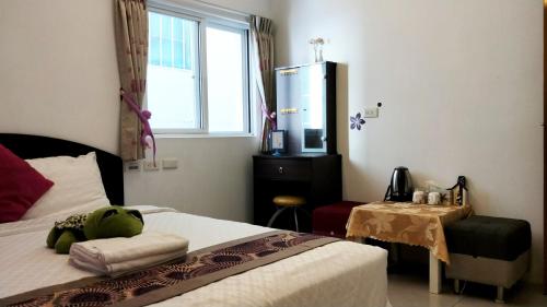 a bedroom with a bed and a table and a window at Nandian Homestay in Eluan