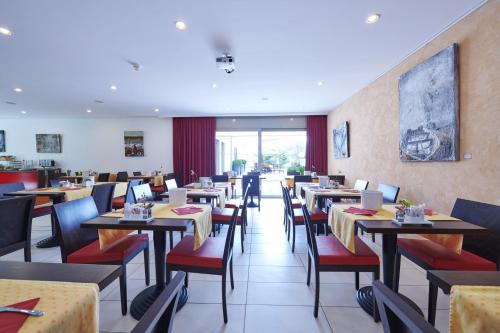 une salle à manger avec des tables et des chaises dans un restaurant dans l'établissement Hotel la Meridiana, Lake & SPA, à Ascona