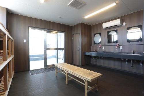 a bathroom with a sink and a bench in it at Hotel Sunplaza in Osaka