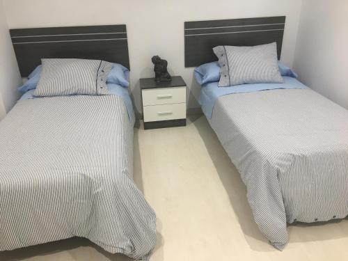a bedroom with two beds and a teddy bear between them at Castro Sun And Beach in Castro-Urdiales
