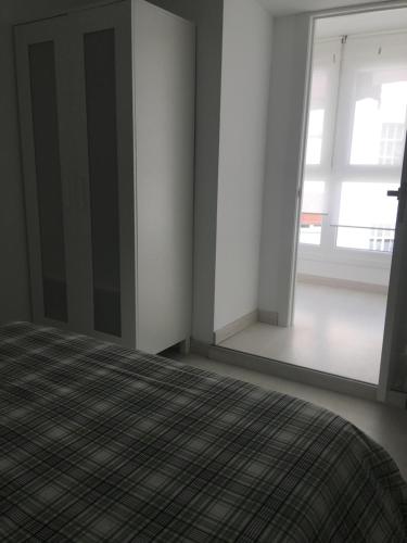 a bedroom with a bed and a large window at Castro Sun And Beach in Castro-Urdiales