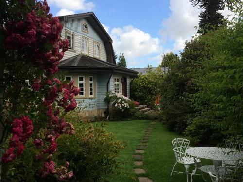 una casa con mesa y sillas en el patio en Hotel Serenade de Franz Schubert, en Frutillar