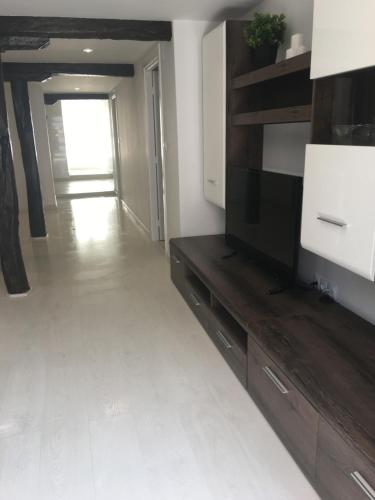 a living room with a television and a white floor at Castro Sun And Beach in Castro-Urdiales