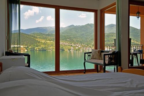 a bedroom with a large window with a view of a lake at Keep calm Lake edition in Konjic