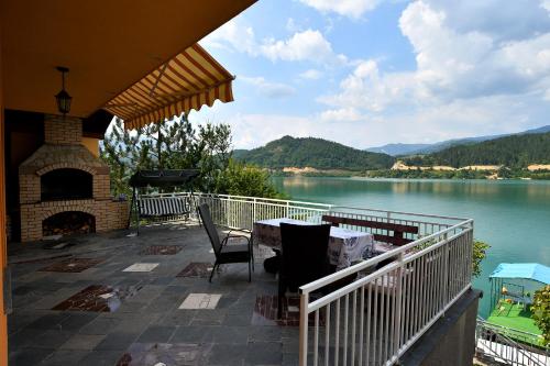 a patio with a table and a fireplace with a view of a lake at Keep calm Lake edition in Konjic