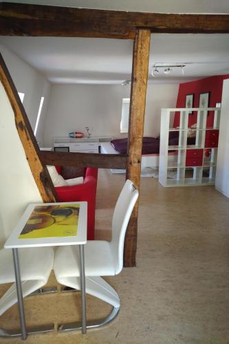 a living room with a table and a chair at FeWos im alten Bahnhof in Lauterecken