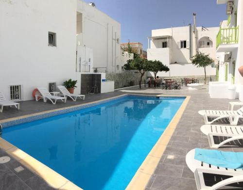 a swimming pool with lounge chairs and a hotel at Frangiscos in Parikia