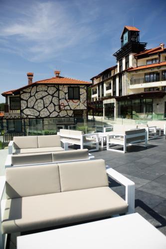 a group of white benches in front of a building at Ruskovets Thermal SPA & Ski Resort in Bansko