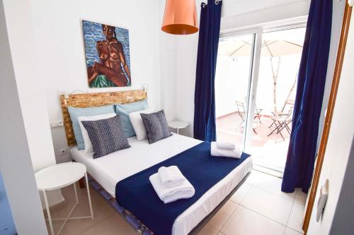 um quarto com uma cama com cortinas azuis e uma janela em Malaga City Suites Barceló 30 em Málaga