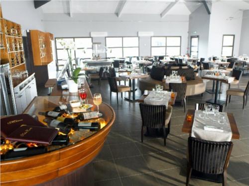 a dining room with tables and chairs and a restaurant at Hôtel Restaurant AKENA La Brède in La Brede