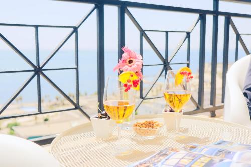 a table with three glasses of wine and a view of the beach at B&B Seataly by W Signature Experiences in Civitavecchia