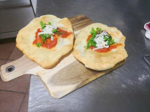 two pizzas sitting on a wooden cutting board at La Mandra in Morino