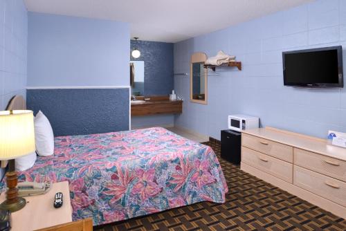 a hotel room with a bed and a flat screen tv at Americas Best Value Inn & Suites, Near The Titanic Museum on 76 in Branson