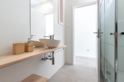 ein Badezimmer mit zwei Waschbecken und einem Spiegel in der Unterkunft Slowlife Furadouro in Furadouro