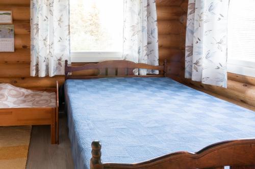 1 dormitorio con 1 cama en una cabaña de madera en Leenan tupa, en Sonka