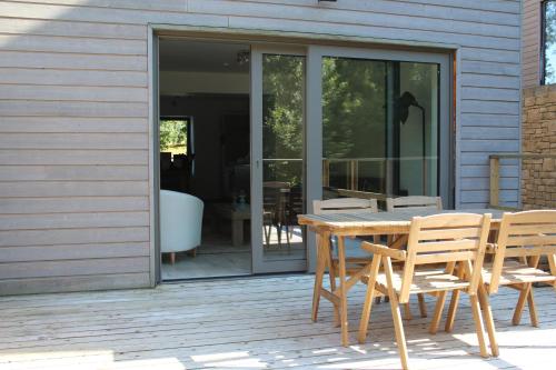 a wooden table and chairs on a patio at Les hauts de Meez in Dinant