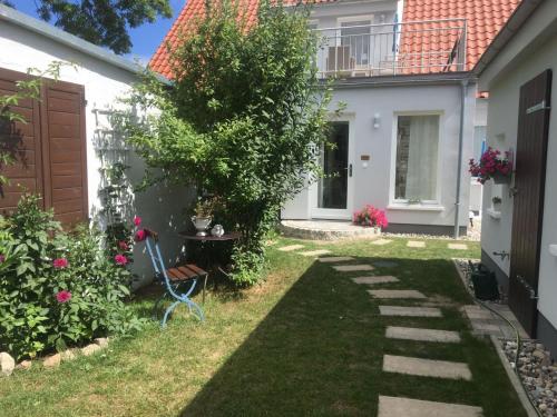 a garden with a tree and a house at Haus Vicus in Greifswald