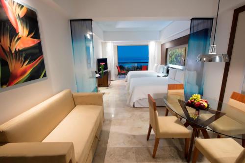 a hotel room with a bed and a living room at Krystal Grand Nuevo Vallarta in Nuevo Vallarta 