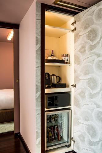 a small kitchen with a refrigerator and a microwave at Hôtel du Rond-point des Champs-Élysées - Esprit de France in Paris
