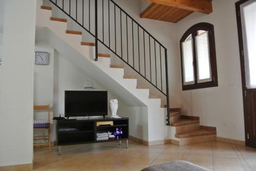 a living room with a tv and a staircase at Il Ghiandolino in Imola