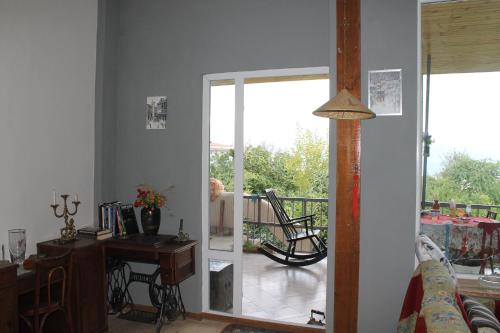 a living room with a door open to a balcony at L House in Tʼelavi