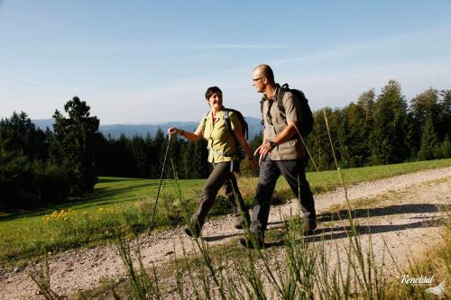 two men walking down a dirt road with backpacks at Hotel Restaurant Rebstock in Oppenau