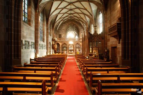 an empty church with a red carpet in the aisle at Hotel Restaurant Rebstock in Oppenau