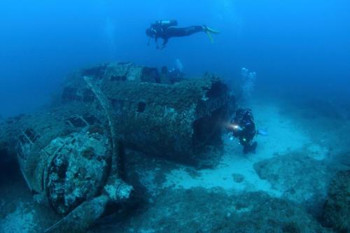 a person in the ocean next to a sunken ship at Modern 2BR Sliema Apartment in Sliema