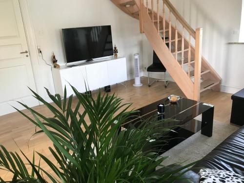 a living room with a tv and a couch at Centralt i Gentofte i 2 plan, ved S-Tog og busser in Gentofte