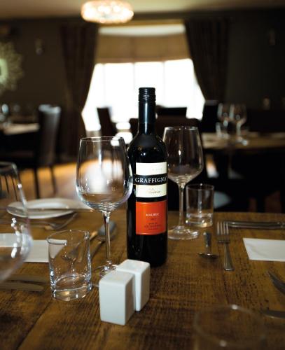 a bottle of wine sitting on a table with glasses at Twin Oaks Hotel in Chesterfield