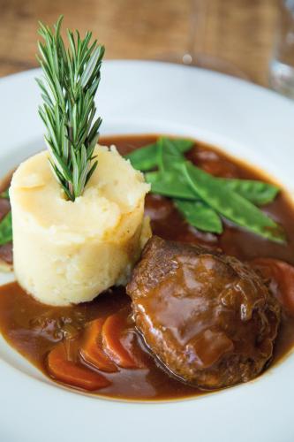 a plate of food with a piece of meat and gravy at Twin Oaks Hotel in Chesterfield