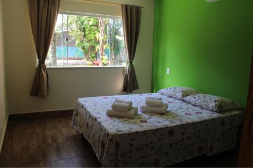 Un dormitorio con una cama con paredes verdes y una ventana en PachaMama Flats - Taipu de Fora, en Barra Grande