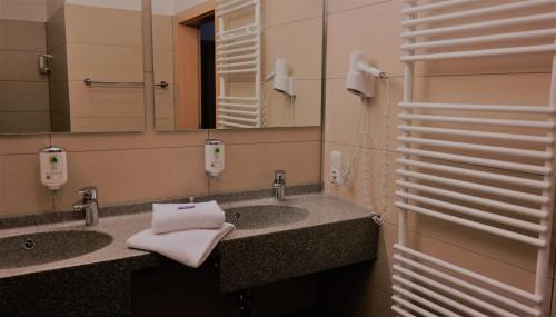 a bathroom with two sinks and a mirror at GS Hotel Mindelheim in Mindelheim