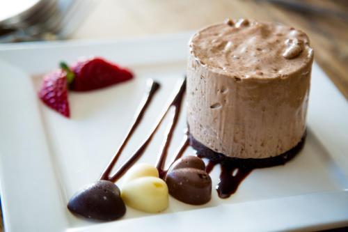 a piece of chocolate cake on a white plate with two forks at Twin Oaks Hotel in Chesterfield