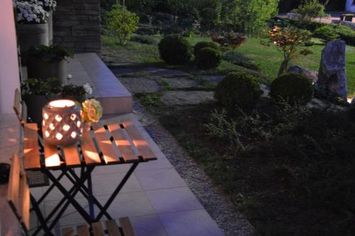 a candle sitting on a bench in a garden at MAPLE place in Pivka