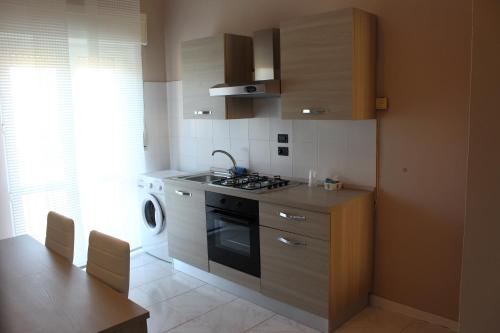 a kitchen with a stove and a sink and a dishwasher at La Maison in Vallata