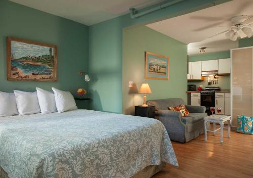 a bedroom with a bed and a chair and a kitchen at The Provincetown Hotel at Gabriel's in Provincetown