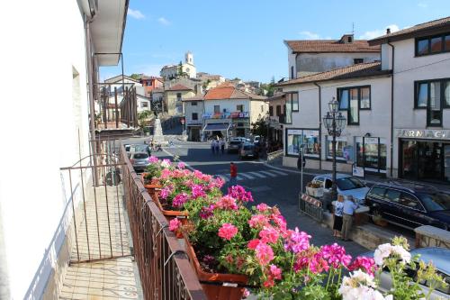 a balcony with a bunch of flowers on a street at La Maison in Vallata