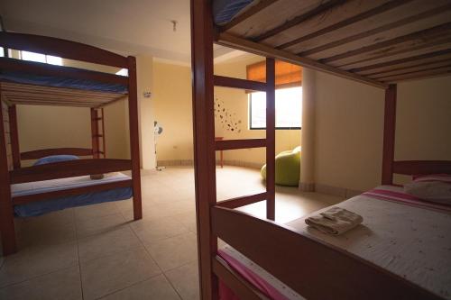 a room with three bunk beds and a bathroom at El Mural Backpackers in Tarapoto