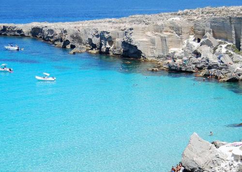 a large body of water with people swimming in it at Egusa73 Favignana in Favignana