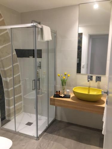 a bathroom with a yellow sink and a shower at Egusa73 Favignana in Favignana