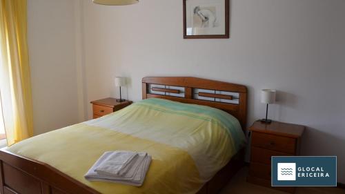 a bedroom with a bed with two night stands and two lamps at Casa Ouriceira, Centro Ericeira in Ericeira