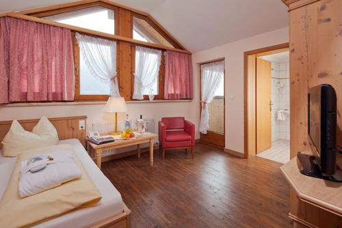 a bedroom with a bed and a table and a chair at Hotel Magdalena im Zillertal - Urlaub mit Hund in Ried im Zillertal