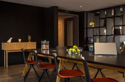 a dining room table with chairs and a bowl of fruit at Najeti Hôtel Lille Nord in Bondues