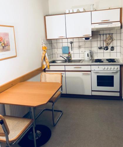 een keuken met een tafel, een wastafel en een fornuis bij Ferienwohnung König Max in Bad Alexandersbad