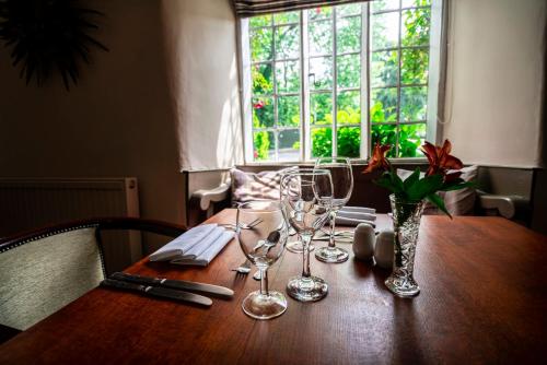 
a dining room table with a glass of wine on it at West Arms Hotel in Llanarmon Dyffryn-Ceiriog
