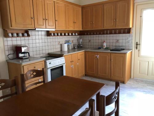 a kitchen with wooden cabinets and a wooden table with a table sidx sidx at Leonidio Climb2red home in Leonidion