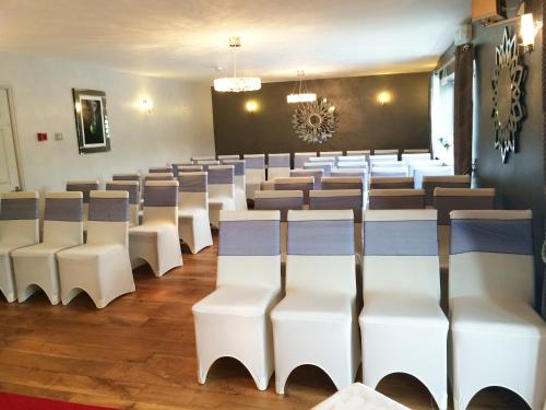 a room with rows of chairs and a chalkboard at Twin Oaks Hotel in Chesterfield