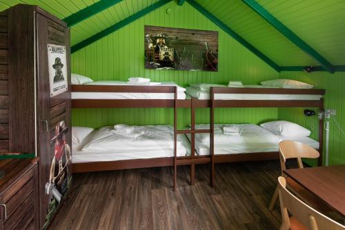 a room with two bunk beds in a green room at LEGOLAND Wilderness Barrels & Cabins in Billund